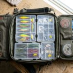 Organized heavy duty fishing tackle backpack open on a clean background.